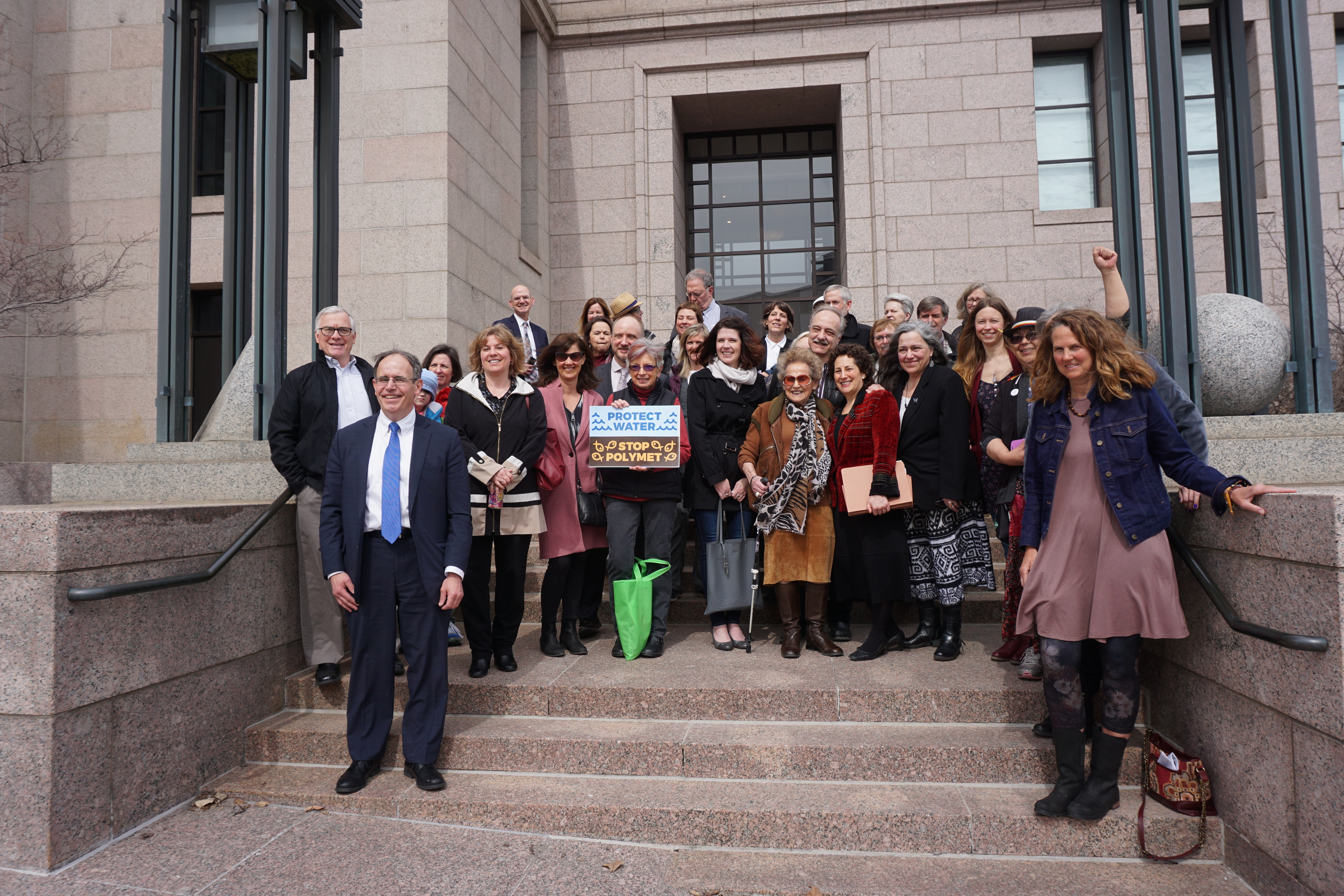 a group of people stand outside the capitol building