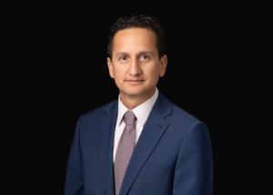 photo of Nicolas Vargas, a man with short hair, in a dark suit against a black background 