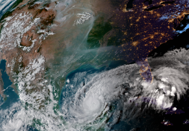 A satellite view of North America on October 7, 2024, showing wildfire smoke from the west snaking across the middle of the continent, and a Category 5 Hurricane Milton churning in the Gulf of Mexico.